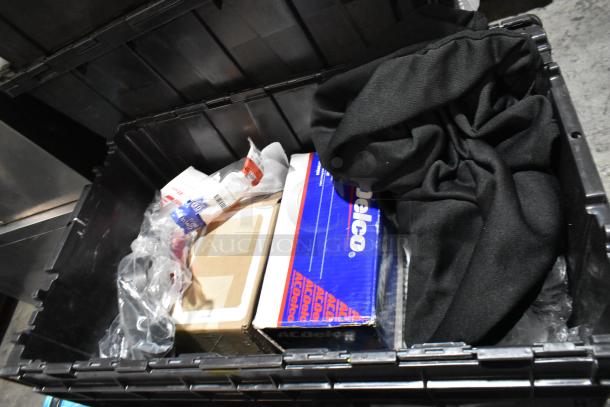 Black poly bin containing various items, including black floor mats, headphones in packaging, and an AC Delco box.