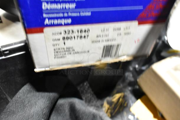 Lot of various items in black poly bin, including floor mats and headphones. Box with label “ACDelco 323-1240.”