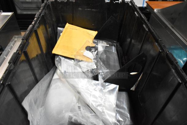 Black poly bin containing various items, including floor mats and cable ties, mixed condition, envelope and plastic bags visible.