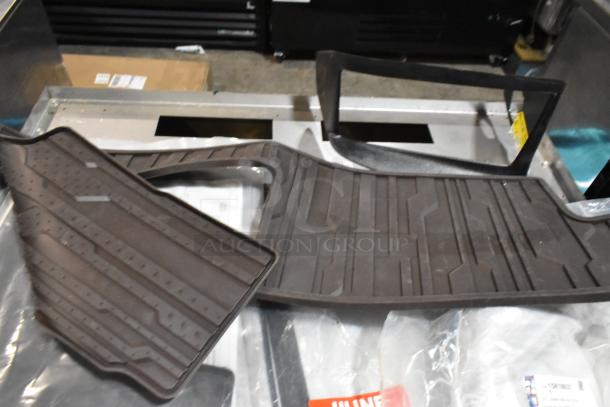 Lot of items in black poly bin: floor mats with textured patterns, cable ties, mixed condition, visible packaging.