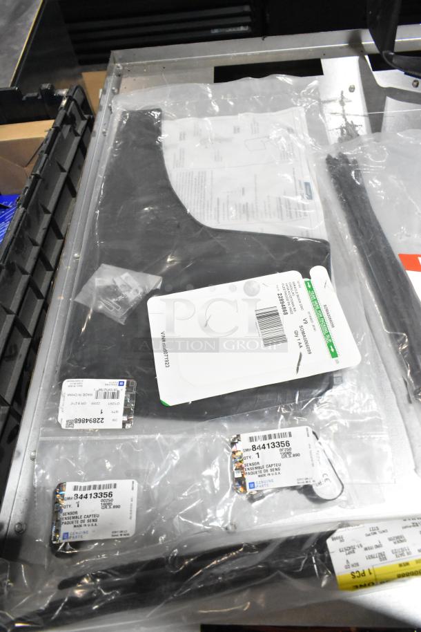 Lot of floor mats and cable ties in black poly bin; includes labeled parts in clear packaging.