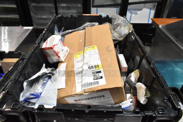 Lot of various items including wheel locks and 23305978 stabilizer shaft insulator in a black poly bin, labels visible.