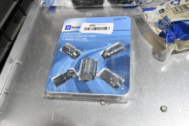 Wheel Locks lot with 23305978 stabilizer shaft insulator in a black poly bin. GM packaging, new condition, assorted parts.