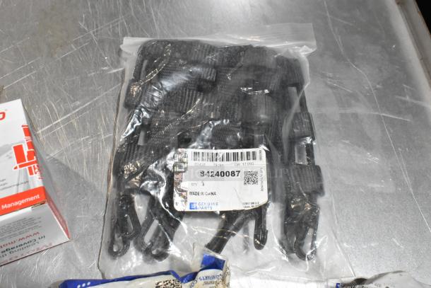 Lot of various items in black poly bin, including wheel locks and 23305978 stabilizer shaft insulator. Clear plastic bag with item label.