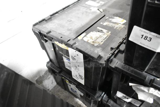 Black poly bin containing various items, including an oil filter and GM 84126999 emblem. Seen with labels and markings on the exterior.