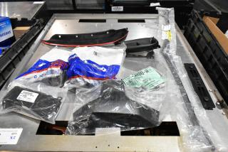 Lot of various items, including GM 84713664 door handles, in a black poly bin. Items in original packaging, assorted conditions.