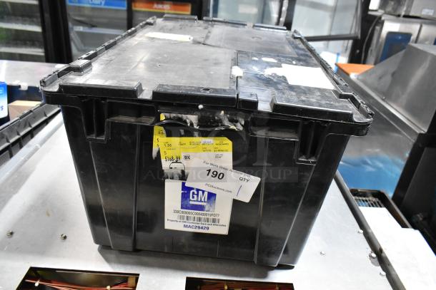 Black poly bin containing various items including GM 84713664 door handles. Labels and tags visible.