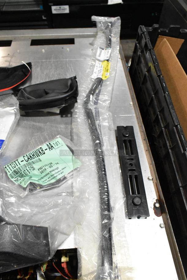 Lot of miscellaneous items, including GM 84713664 door handles, in a black poly bin. Various parts sealed in packaging.