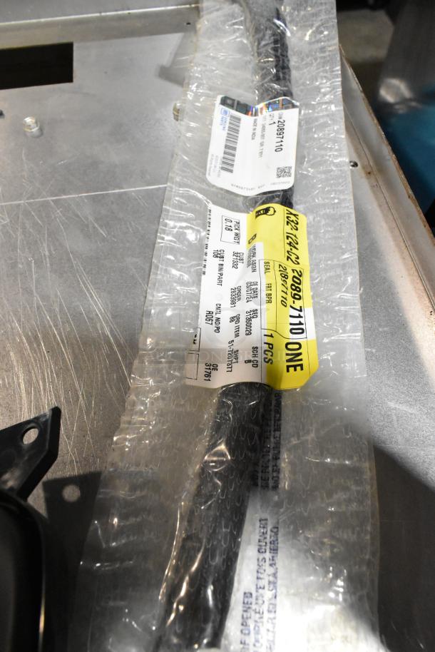 Lot of various items including GM 84713664 door handles in sealed packaging, placed in a black poly bin. Labels show item numbers.