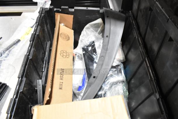 Lot of various items including GM 84713664 door handles in a black poly bin. Boxes and packaging visible. Good condition.