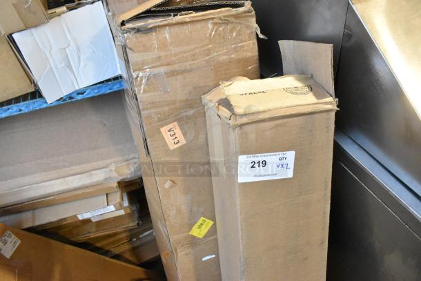 Two sealed boxes, one labeled for Buick floor mat, showing signs of wear. Lot number 219 marked for auction.