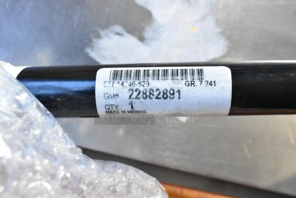Barcoded label on a black rod showing GM# 22882891, made in Mexico, part of Buick floor mat package.