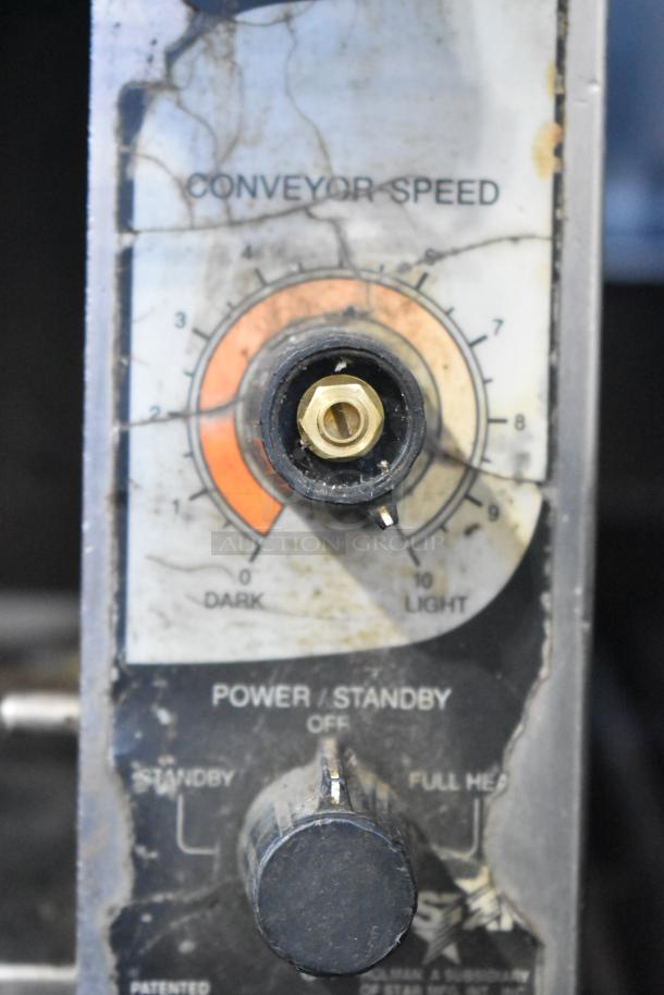 Holman stainless steel conveyor toaster oven control panel, showing adjustable conveyor speed and power settings.