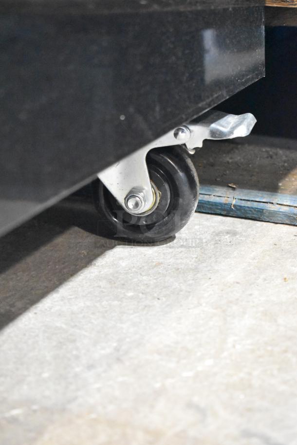 Mainstreet 829GMC49B cooler, metal with two doors, on commercial casters. 115 volts, 1 phase. Close-up of caster wheel.