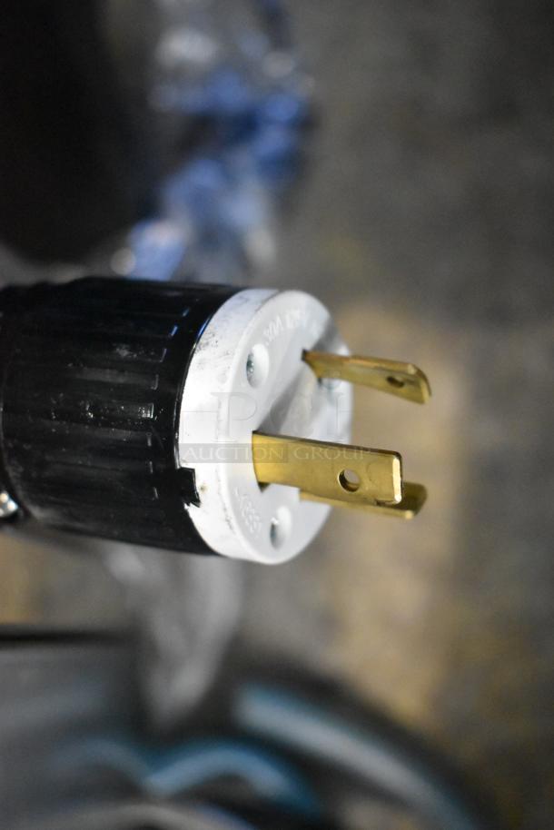 Close-up of a power plug for an Avantco 193VOA60B open air merchandiser. Black casing with metal prongs.