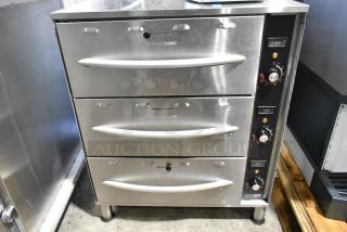 Brand new 2024 ServIt 423WDSFS3 stainless steel triple drawer warmer. Features 120V, 1 phase, with controls for dry/moist settings. Minor dents visible.