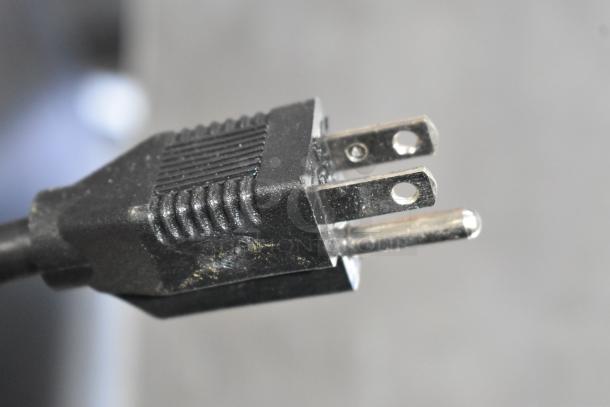 Close-up of a three-prong plug for an Alto Shaam 1200-UP holding cabinet. Plug slightly worn, suitable for 120 volts, 1 phase.