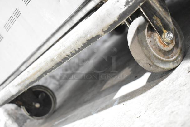 Alto Shaam 1200-UP commercial holding cabinet caster wheel, showing moderate wear on stainless steel frame and wheel.