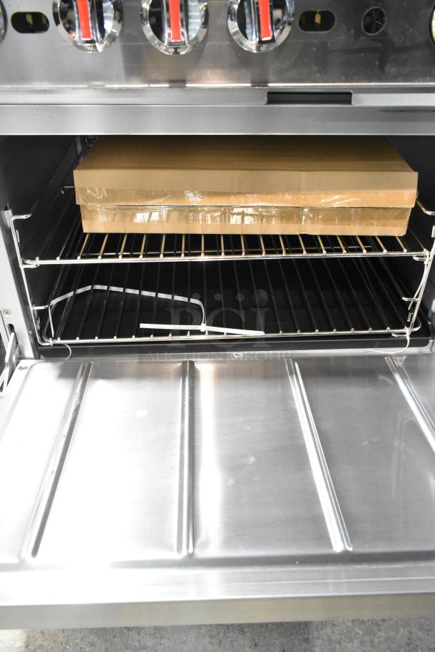 Stainless steel interior of Cooking Performance Group 351S60GS24L range, showing oven racks and packaging.