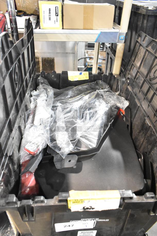 Lot of various items including GMC panels in a black poly bin, with visible labels and packaging.