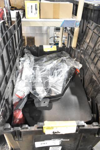 Lot of various items including GMC panels in a black poly bin, with visible labels and packaging.