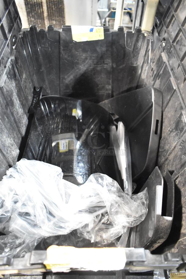 Lot of various items in a black poly bin, including GMC panels. Moderate wear, includes clear plastic wrapping. Auction item, mixed contents.