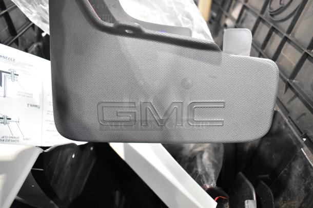 GMC panel in textured material with embossed logo, part of a lot in black poly bin. Includes instruction sheet.