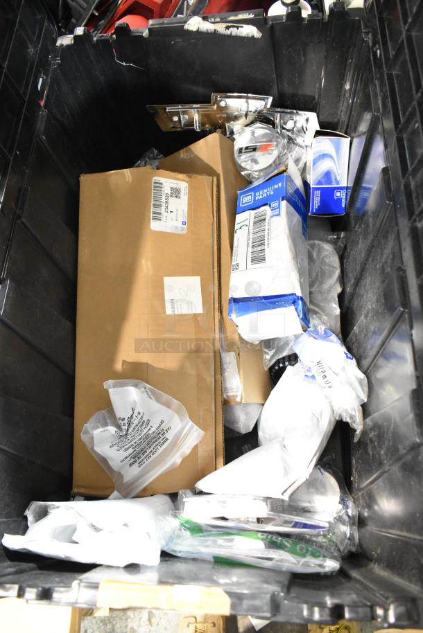 Black poly bin containing assorted items, including automotive parts and packaging labeled “GM Genuine Parts” and a Chevy emblem.