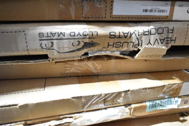 Boxes containing 18 assorted items, including Lloyd heavy plush floor mats. Boxes show wear with visible labels and tape.