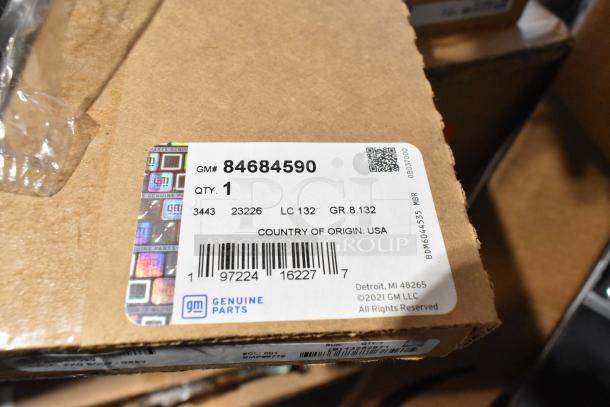 Box of GM Genuine Parts with label 84684590, includes Corvette items and GM exterior trim fender hash marks, new condition.