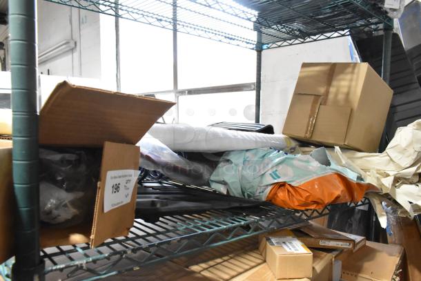 Tier lot of various items, including car mats and coils, on a metal shelf. Includes boxed and wrapped goods, condition varies.