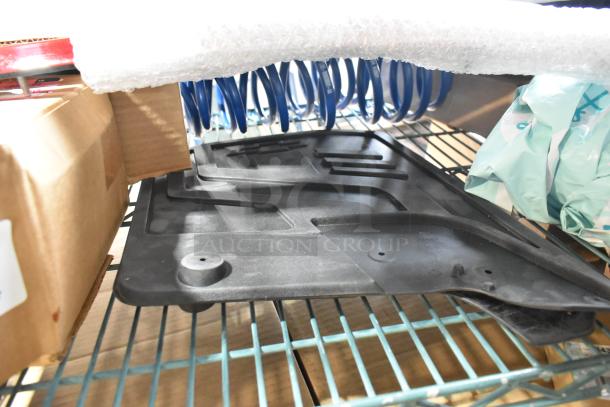 Tiered auction lot with various items, including black car mats and blue coils, on shelving. Condition appears good.