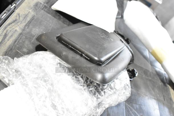 Assorted auction lot featuring black car mat and auto part. Includes visible protective packaging. Good condition.