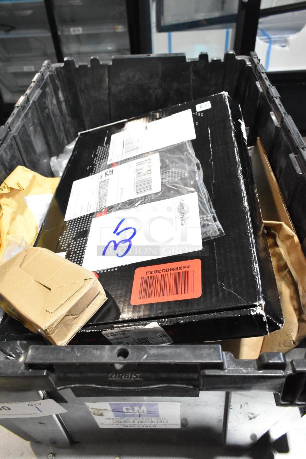 Black poly bin containing various items including wheel locks. Visible shipping labels and barcode. Items appear in used condition.