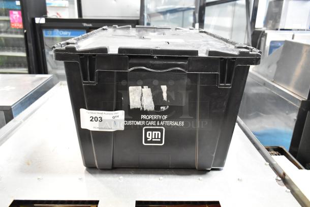 Black poly bin labeled "Property of Customer Care & Aftersales" containing various items, including Hawk Racing disc brake pads.