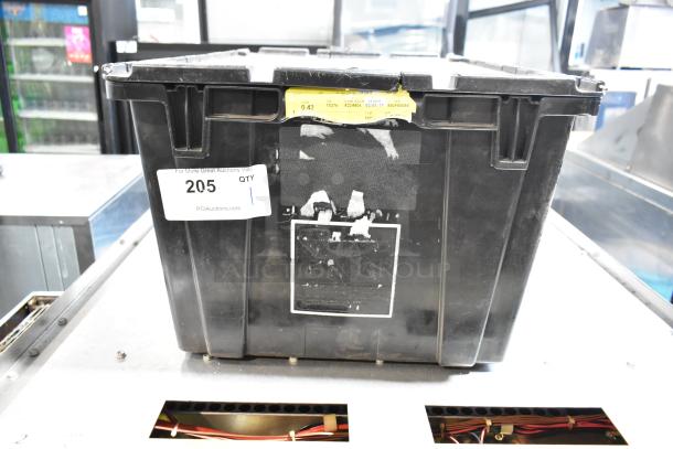 Black poly bin containing various items, labeled "205" with auction site address. Signs of wear visible.