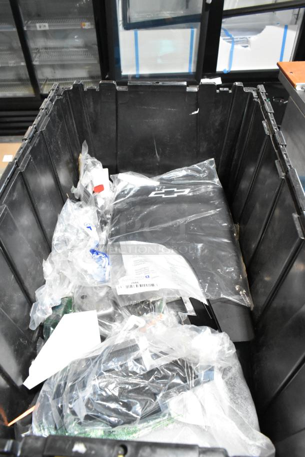 Lot of various items including mat, packaged in a black poly bin. Items include a black mat with a white emblem, several bags, and miscellaneous materials, indicating a mixed collection. Condition appears used.