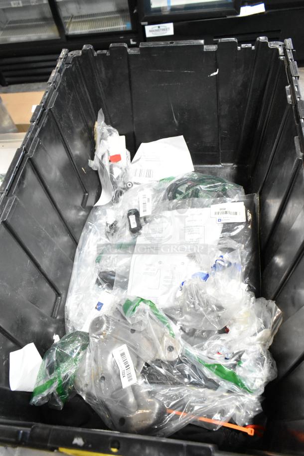 Black poly bin containing various items in sealed plastic bags, labels visible with barcodes and product details.