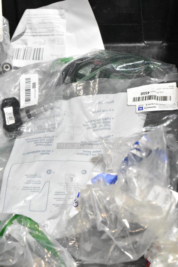 Lot of various items in clear bags inside a black poly bin; includes papers, small parts, and hoses. Tags show item codes.