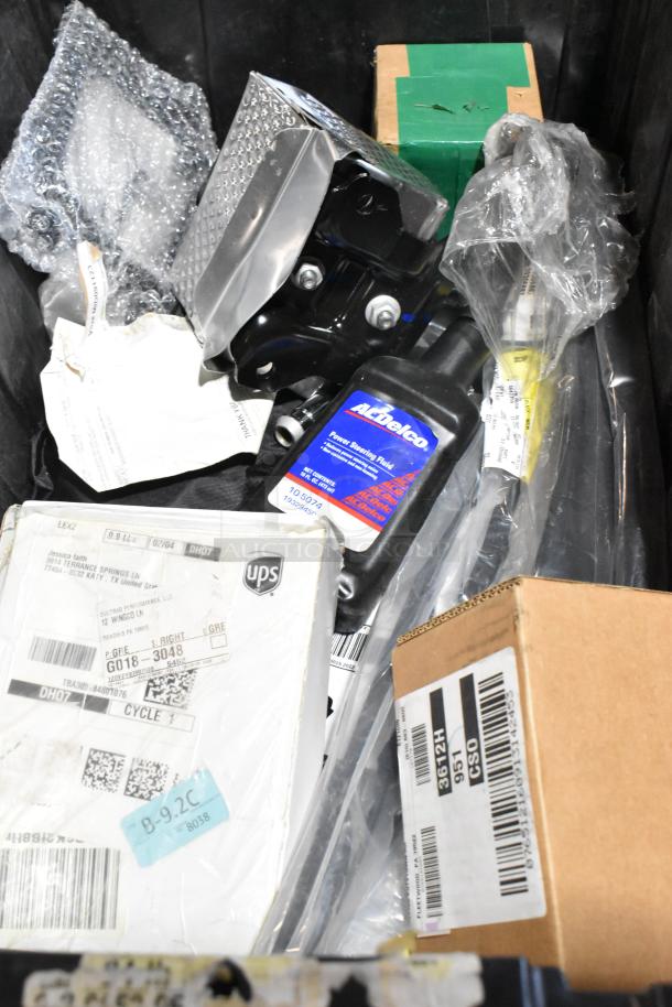 Lot of various items in black poly bin, featuring ACDelco Power Steering Fluid, boxes, and packaging materials.