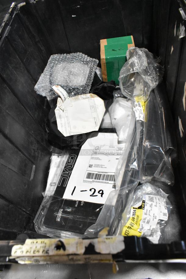 Lot of miscellaneous items in a black poly bin, including ACDelco power steering fluid. Contains various packaging and labels.