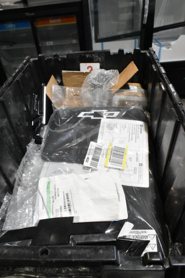 Black poly bin containing various items, highlighted by a GMC emblem; items include labels and packaging.