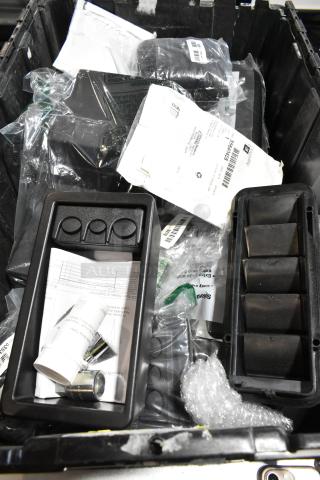 Lot of various items in black poly bin, featuring GM 23221725 tablet holder, packaging, and documents visible.