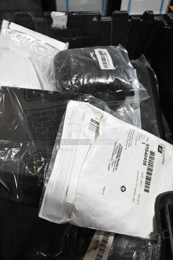 Lot of various items including GM 23221725 universal tablet holder in a black poly bin. Items in packaging with labels.