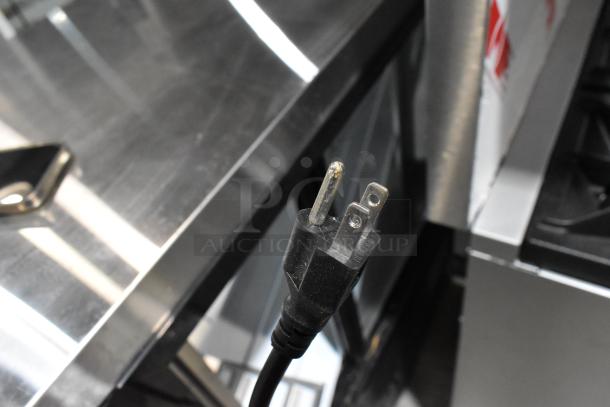 Power cord of Avantco 178DLC82HCB 82" black curved glass refrigerated deli case, shown with prongs visible.