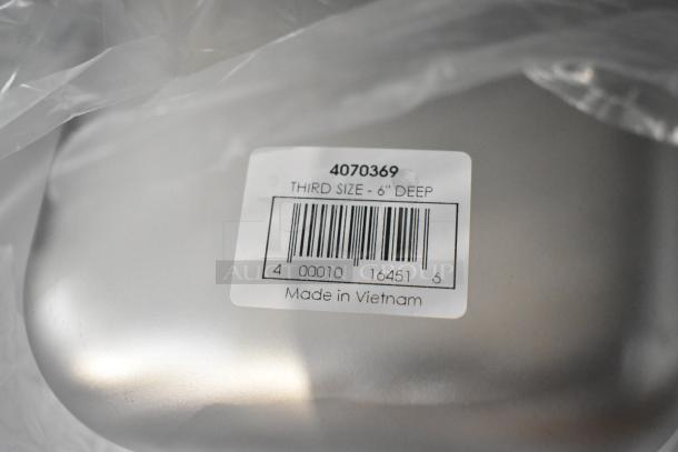 9 scratch and dent stainless steel steam pans. Visible label: "Third Size - 6" Deep, Made in Vietnam."