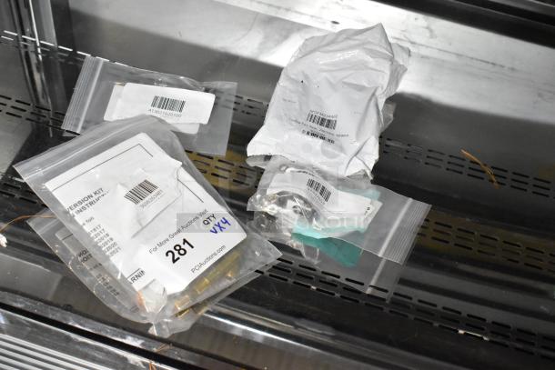Four brand new scratch and dent items including Frymaster kit, Imperial Range bracket, Moffat fan, and Hatco thermostat. Packaged with visible labels indicating item details.