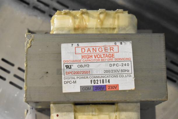High voltage capacitor, model DPC-240, from Digital Power Communications Co., Ltd. Voltage: 208/230V, 60Hz. Warning label visible.