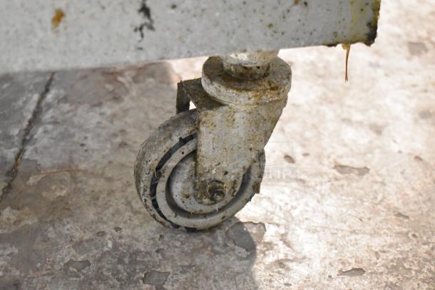 Vulcan 1GR45M-1 deep fryer caster detail, showing wear and dirt on stainless steel commercial caster.