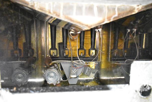 Vulcan 1GR45M-1 deep fat fryer, interior view showing components, wiring, and tubes. Stainless steel, on commercial casters.